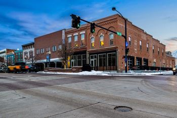 A street view of a city intersection with a traffic light showing green.